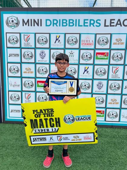 A proud U13 player with his 'Player of the Match' award, showcasing the talent within our older youth squads.
