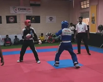 A wide view of the competition mat, where two fighters maintain their distance, looking for an opening. Tactical awareness is a key skill we teach.
