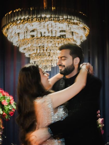 A motion-blur shot of the couple dancing under a chandelier. This artistic photo captures the movement and energy of their sangeet night in a unique and dynamic way.