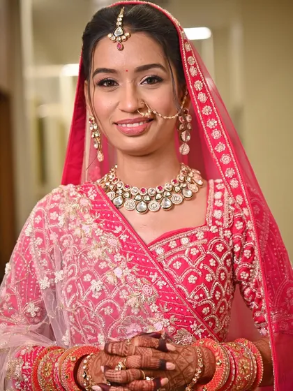 A close-up of this bride's flawless look for her big day. The makeup was kept soft and radiant to complement her bright pink lehenga, complete with a delicate nath and maang tikka.