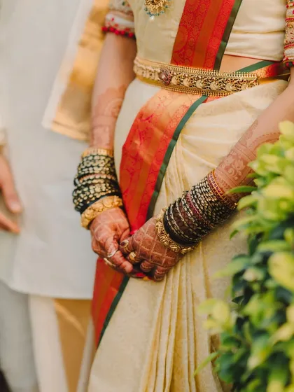 A detailed shot of the bride's hands, adorned with beautiful henna and traditional green and black bangles.