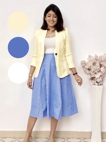 A fresh and summery color palette. The yellow blazer, blue and white striped skirt, and white top create a bright and cheerful look perfect for warm weather.