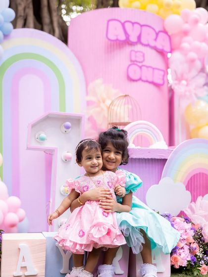 A sweet moment between sisters at Ayra's rainbow and butterfly themed party.