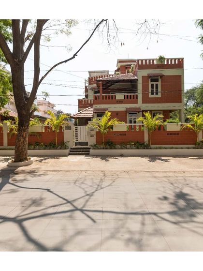 A view of the residence from the street, showing how the building, with its earthy tones and green boundary, settles into its urban context.