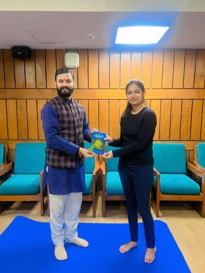 A student from Mauritius receiving a book to supplement her learning during the YTTC.