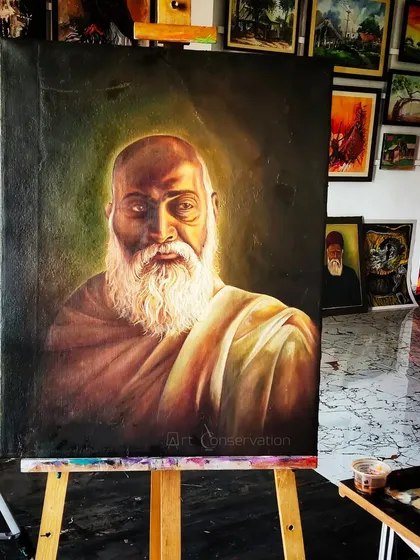 A completed portrait restoration of a spiritual figure, now resting on an easel in my studio. The lighting highlights the restored textures in the beard and cloth, ready to be returned to the client.