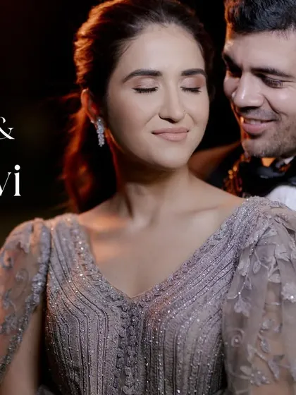A soft, romantic close-up of a couple in formal evening wear. The focus is on her serene expression as he holds her, creating a moment of quiet intimacy and elegance.