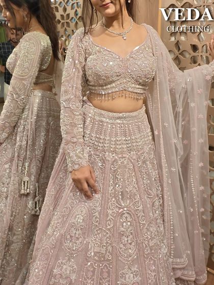 A beautiful pastel pink lehenga with intricate silver embroidery. This pre-loved piece is perfect for a daytime wedding or a sangeet ceremony.