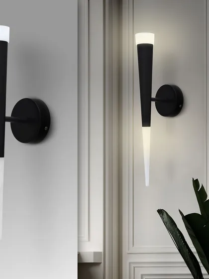 This image shows the torch sconce both off and on, highlighting its sleek black design and the warm light it produces.