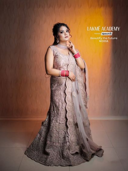 A full-length shot of an elegant evening look. The dusty pink lehenga and diamond jewelry are paired with a soft smokey eye, perfect for a reception or engagement party.