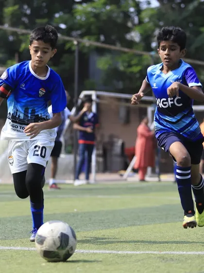 A U13 player dribbles down the wing during a competitive match.