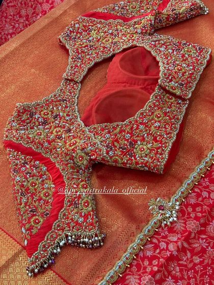 A magnificent red bridal blouse with a sheer back and all-over zardosi work.