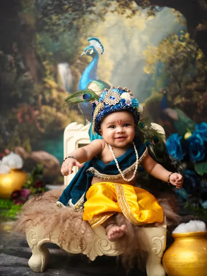 A happy baby Krishna, sitting with his peacock friend. The vibrant colors and rich textures in this setup make for a visually stunning traditional portrait.