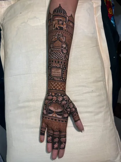 A side view of a traditional bridal arm design. This angle highlights the detailed bands of patterns, including jaali work, elephants, and a custom Sanskrit quote.