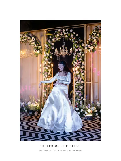 The sister of the bride, styled in a shimmering ivory lehenga, strikes a pose. This look is a perfect example of fuss-free, elegant bridesmaid inspiration for a sangeet or cocktail event.