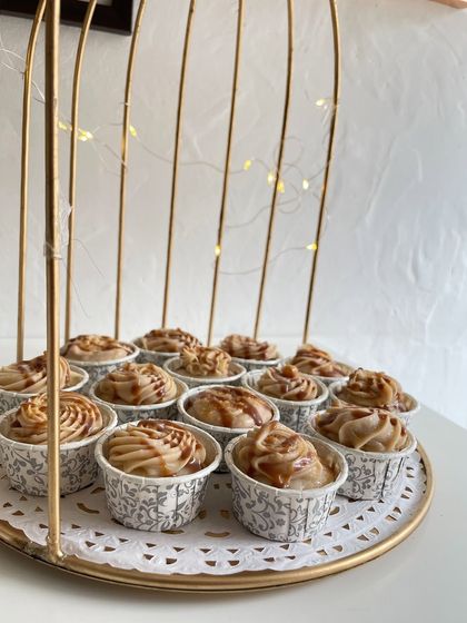 These caramel-swirled cupcakes are beautifully arranged on a golden tray, ready to be served at an event. We ensure every detail of our dessert tables is picture-perfect.