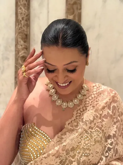 A moment of reflection. The soft makeup and sleek hair were designed to complement the intricate jewelry and ethereal quality of the lace saree.