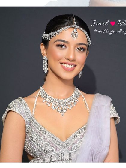 A radiant smile from a modern bride. She is wearing our full minimal diamond set, including the necklace, earrings, and sheeshpatti, perfect for a contemporary white or pastel wedding theme.