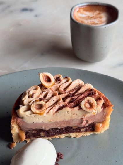 A perfect slice of our dark chocolate and hazelnut tart, served with a scoop of vanilla ice cream and a coffee. A simple, elegant dessert.