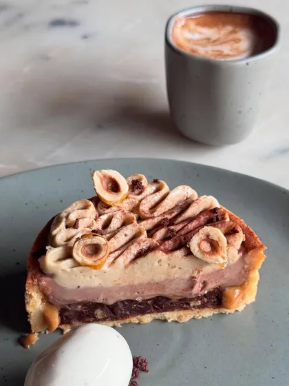 A slice of our Hazelnut Tart, a rich and nutty dessert, paired perfectly with a cup of coffee.