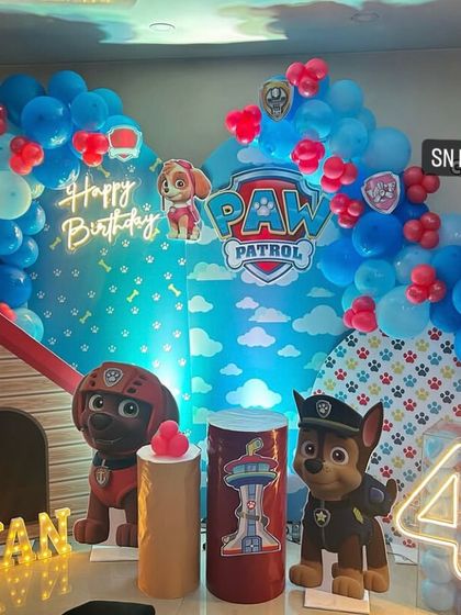 A powerful Paw Patrol theme for Aryan's 4th birthday. The decoration includes a doghouse prop, character standees, and a blue balloon arch, ready for action.