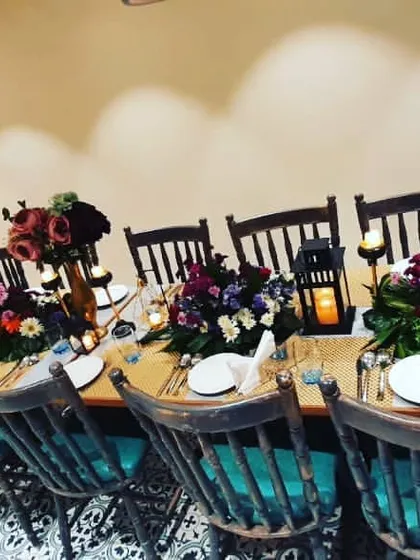 Here is an example of an intimate birthday dinner I styled for a small group. The setup included a long table with rustic wooden chairs, elegant floral centerpieces, and personalized details like the 'Happy Birthday Rhia' sign to make the guest of honor feel special.