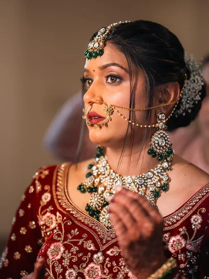 A candid moment of the bride getting ready, her expression serene and beautiful.