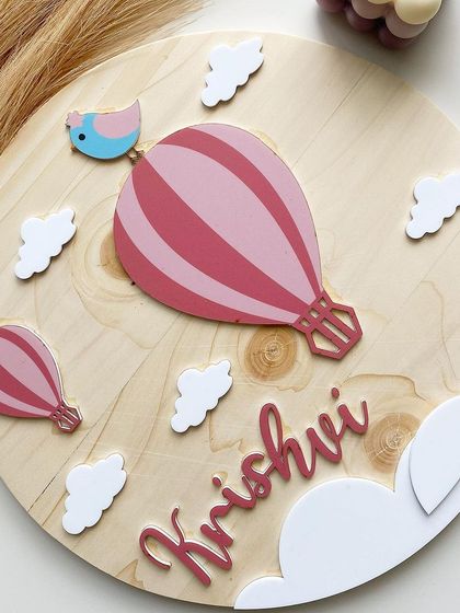 A closer look at the hot air balloon theme, this time in a lovely pink for Krishvi. Each element, including the tiny bird on top, is carefully cut and painted to bring the whole piece to life.