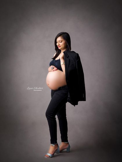 A modern and powerful look. This "boss mama" style with a black blazer and bare bump is for the confident woman who wants to celebrate her strength.