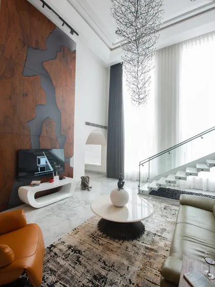 Another angle of the Gallery House living room, highlighting the dramatic scale, the flow of natural light from the tall windows, and the custom-designed television console.
