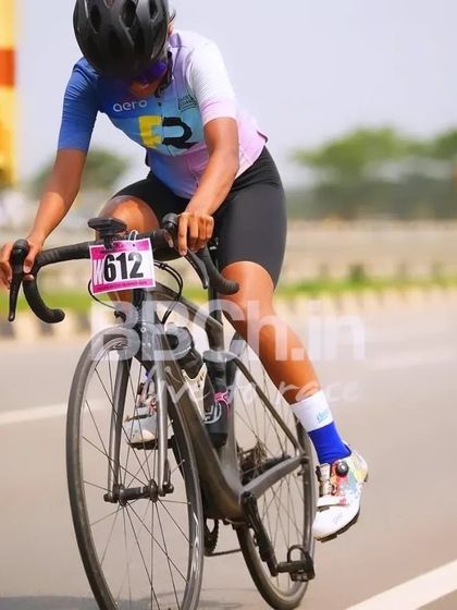 A female rider, focused and in an aerodynamic position, pushes hard during the race.