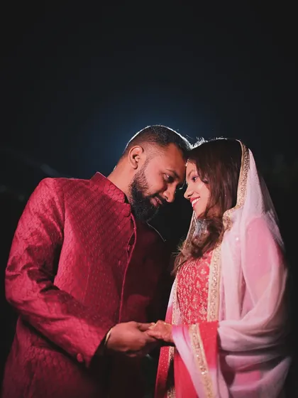 A beautiful, softly lit portrait of a couple on their wedding night. Their gentle hold and happy expressions tell a story of love and partnership.