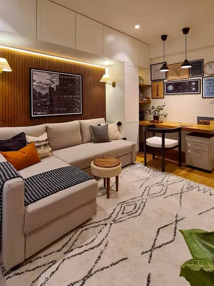 I specialize in creating multifunctional rooms that work for your lifestyle. This space serves as a cozy media room for movie nights, a guest room with a sofa bed and hidden storage, and a functional home office. The wood-paneled accent wall adds warmth and texture, making it a favorite spot in the house.