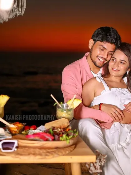 A romantic beachside picnic at sunset, capturing a cozy and intimate moment for a pre-wedding shoot.