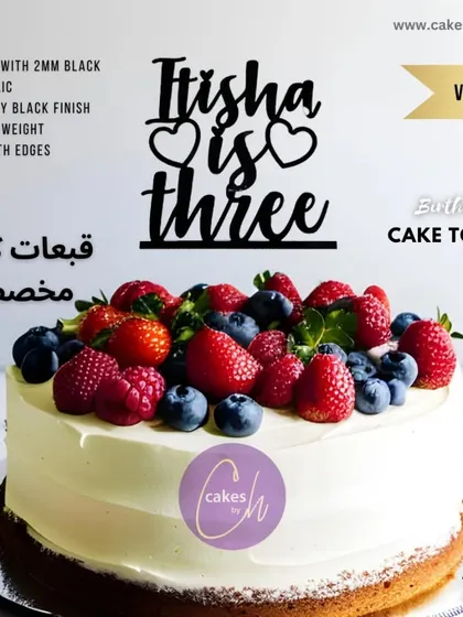 A mockup of the "Itisha is three" topper in black on a berry-covered cake, creating a beautiful and delicious-looking combination.