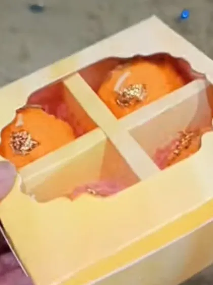 My 4-cavity yellow gift box, shown with Ladoo candles inside. The divider keeps the items separate and secure.