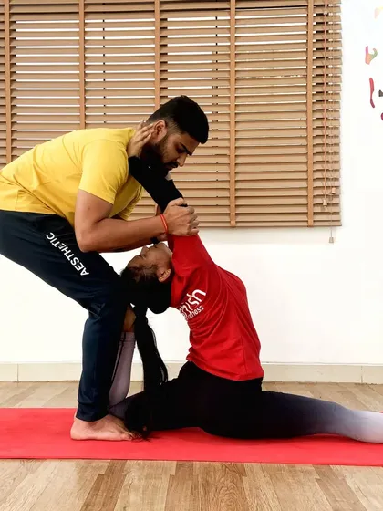 A deep, assisted split in Hanumanasana. My guidance helps the student to open their hips fully and safely, working towards the full expression of the pose.