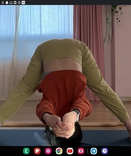 Guiding a student through Prasarita Padottanasana (Wide-Legged Forward Bend) in an online class. Clear instruction and visual feedback ensure you can practice even deep forward bends safely and effectively at home.