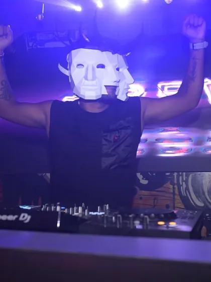 Mask on, hands up. Me in my element during a Halloween set, bringing a mysterious and high-energy vibe.