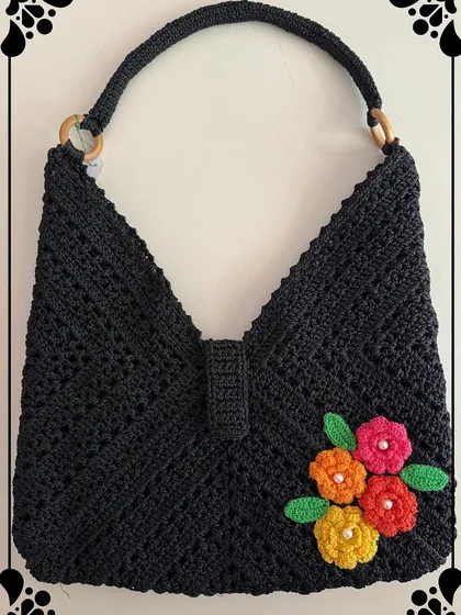 My black beauty bag is a true showstopper. The intricate crochet work is highlighted with bright, handmade flowers, creating a unique piece that will grab everyone’s attention.