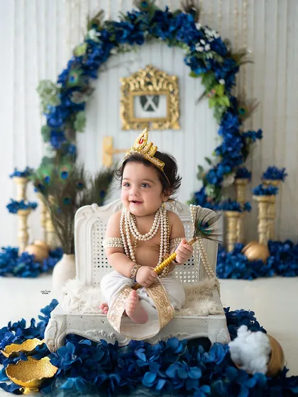 This little Krishna is sitting regally on his throne, ready to rule Vrindavan. The royal blue and gold setup is perfect for a festive feel.