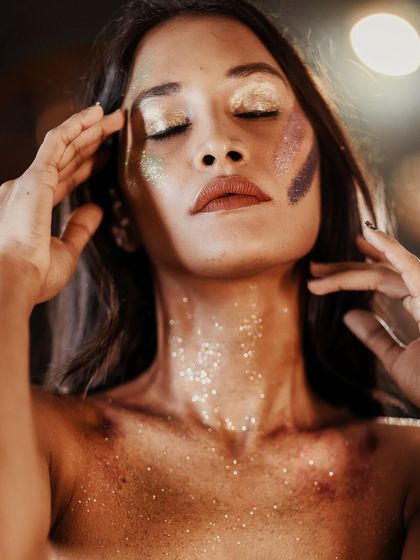 A fine art portrait exploring texture and light. The subject is adorned with glitter, creating a cosmic, ethereal look that is both beautiful and introspective.