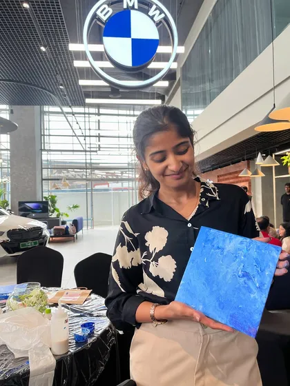 Holding up a finished fluid art piece at the BMW showroom. The colors and design of the cars inspired our art that day.