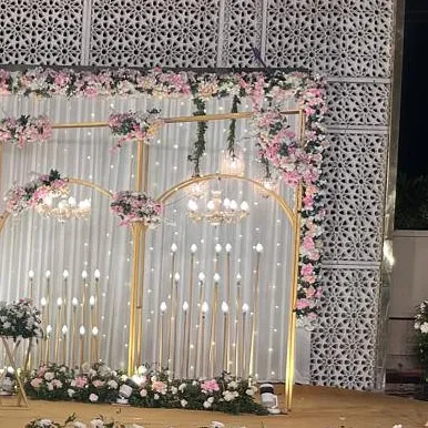 A side view of the stage, highlighting the intricate floral work and the warm glow of the candle-like lights.