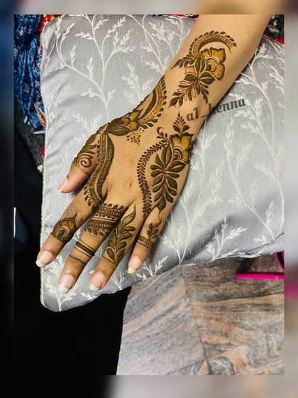 A single hand showcasing a beautiful Arabic floral vine design.