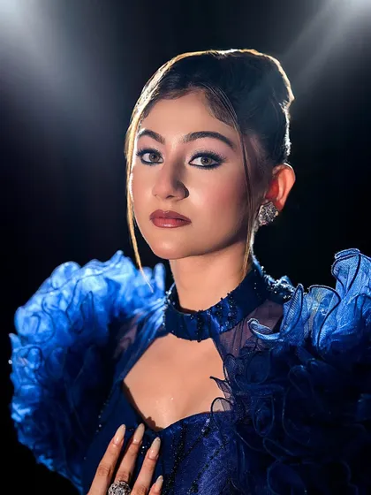 A striking close-up portrait of the blue gown look.