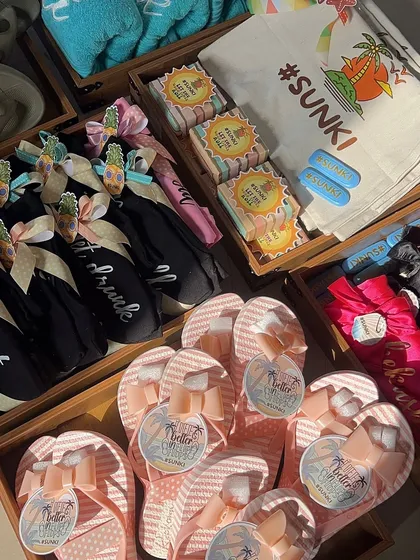 An inside look at the packing process for the beach bachelorette hampers. You can see the cute flip-flops, custom-tagged items, and personalized t-shirts all ready to be assembled.