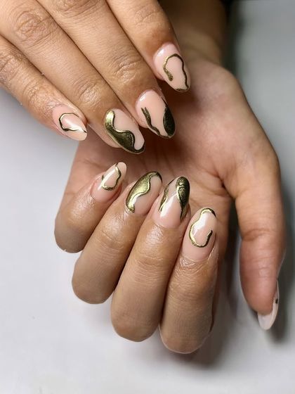 Another example of abstract gold chrome art. The fluid, organic shapes give the nails a unique, custom-designed feel that is both edgy and elegant.