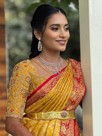 This bride glows in a traditional yellow and red Kanchivaram saree. I designed a heavily embroidered yellow blouse to match, creating a cohesive and stunning look for her wedding ceremony.