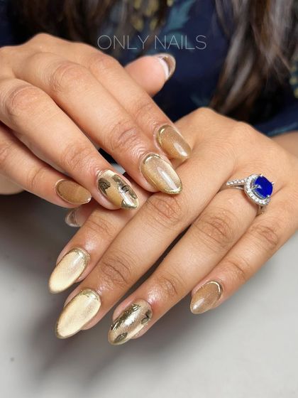 A sophisticated and elegant wedding nail design. This set features a beautiful golden-brown cat eye effect, accented with delicate gold foil and a subtle gold chrome French tip for a touch of luxury.